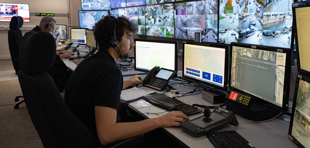 CCTV operator at bank of CCTV monitors.