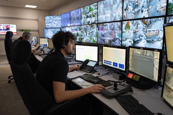 CCTV operator at a bank of CCTV screens.