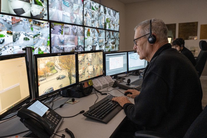 CCTV operator at a bank of CCTV screens.