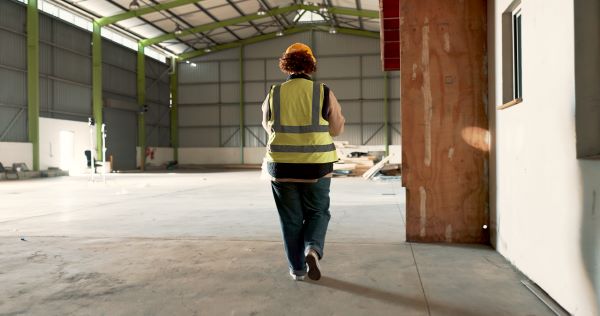 Construction worker walking alone in a construction site.